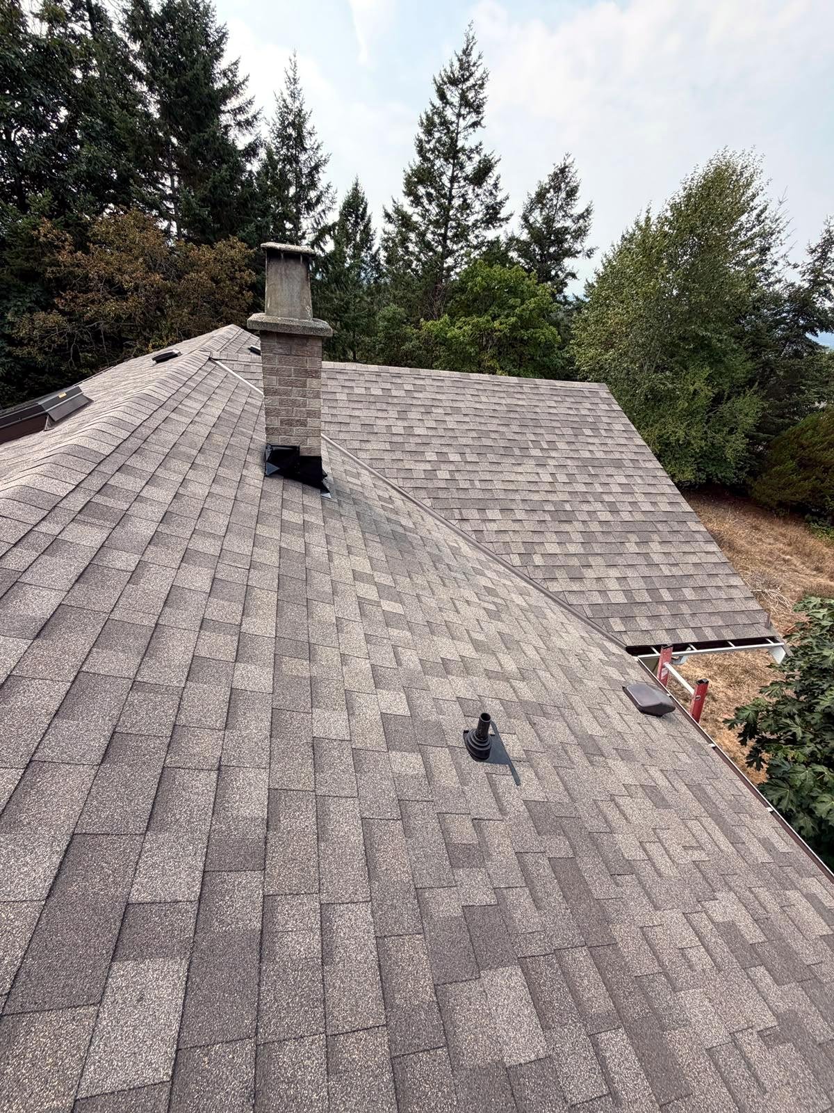 Wood-toned shingle roof with chimney flashing by Eco Roofing Ltd, Nanaimo BC