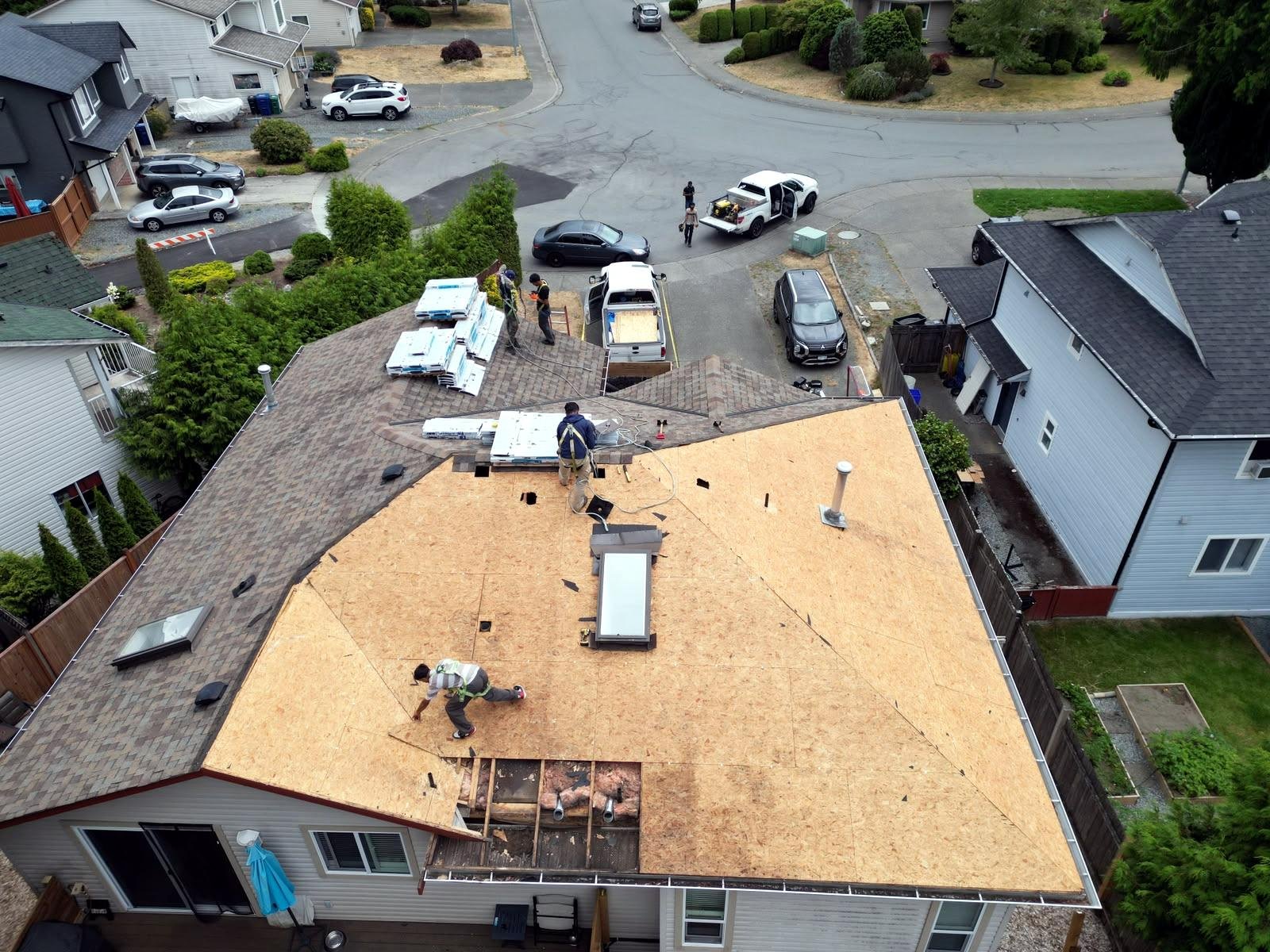 Crew tearing off a storm-damaged roof down to the deck in Nanaimo
